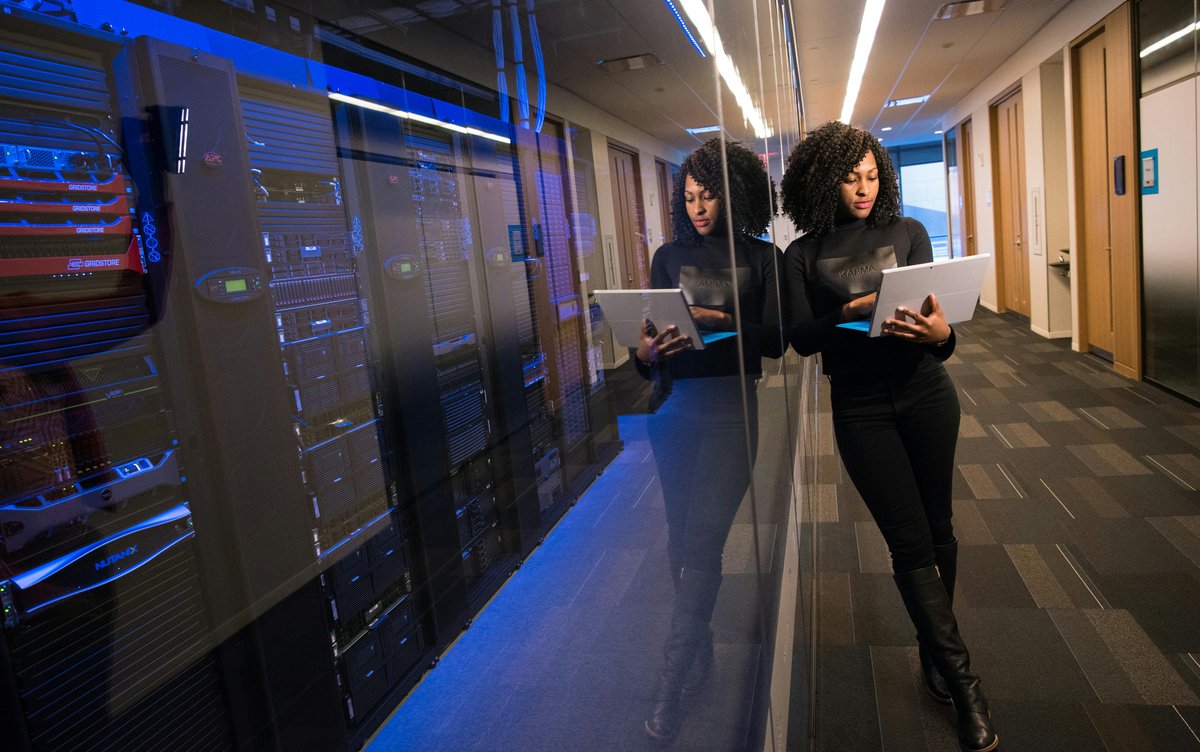 Woman with computer in server room